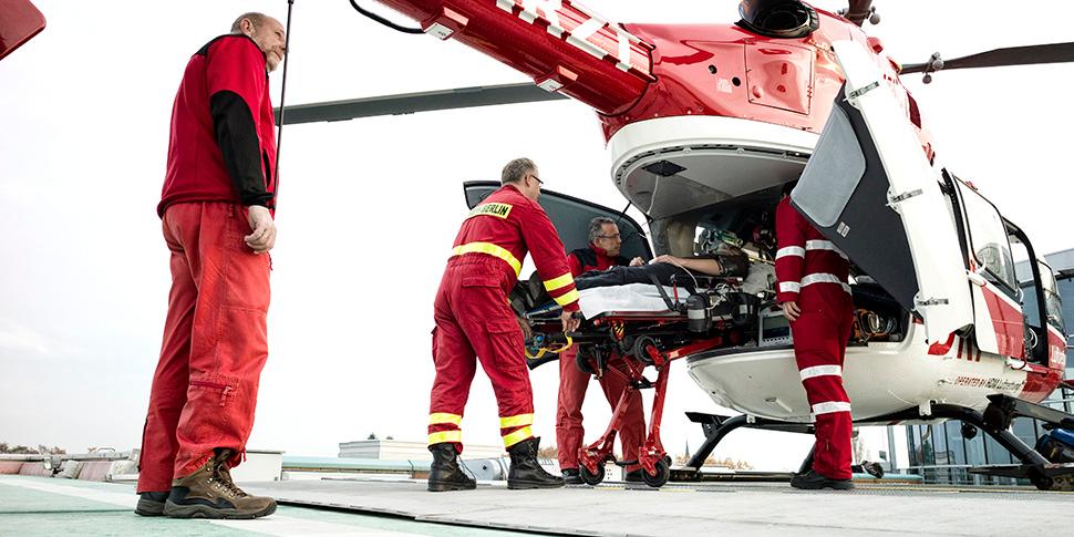 Transportliege wird von Notfallsanitätern in einen Hubschrauber verladen