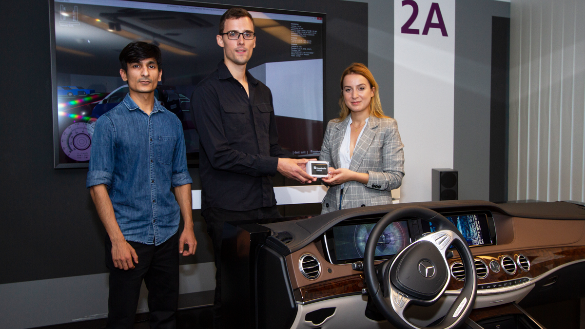 Der Studentin mit dem besten Testfahrt-Ergebnis wird ein Preis überreicht. Auch der Zweitplatzierte wird von FOKUS-Forscher Daniel Becker bei der Siegerehrung gewürdigt.