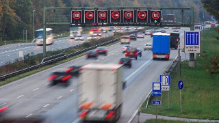traffic on german autobahn with speed limit signs, shot at twilight, slight motion blur