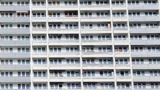 weiß-graue Hausfassade eines Wohnblocks in Berlin mit Fenstern und Balkonen