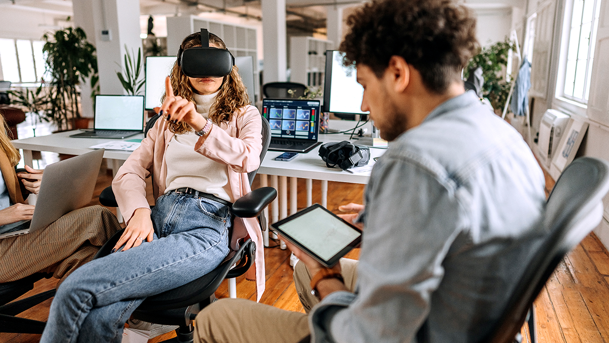 Young game developers testing VR goggles for their new game in the office