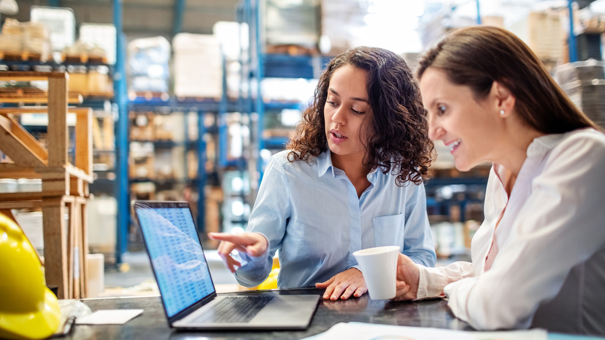 ESPRI, News: ELITE Zwei Geschäftsfrauen arbeiten zusammen an einem Laptop.