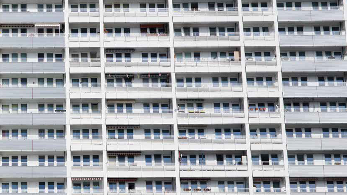 DPS, Labor: Blockchain Werkstatt weiß-graue Hausfassade eines Wohnblocks in Berlin mit Fenstern und Balkonen