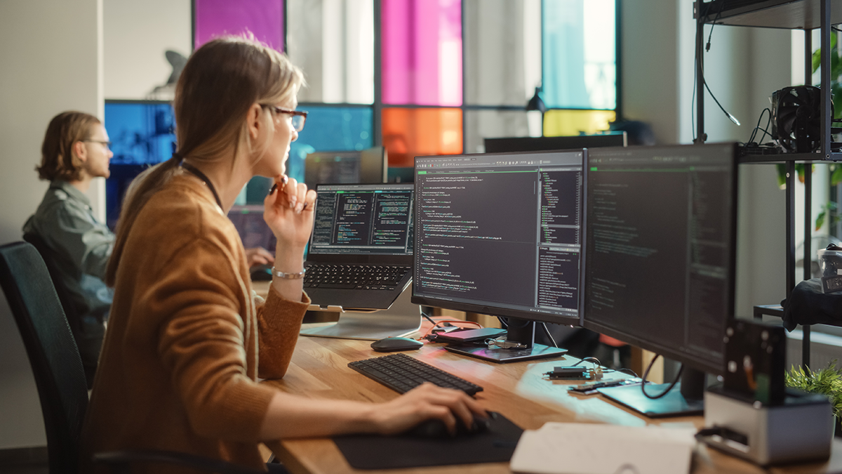DPS, News: Management von digitalen Geschäftsprozessen mit Towerpark Büro in dem zwei Personen an mehreren Bildschirmen Code programmieren