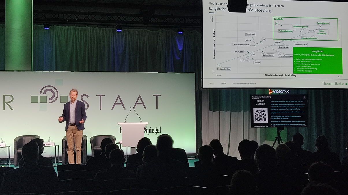DPS, News: Themenradar 2025 Geschäftsbereichsleiter Dr. Jens Klessmann bei einem Vortrag auf der Konferenz Digitaler Staat