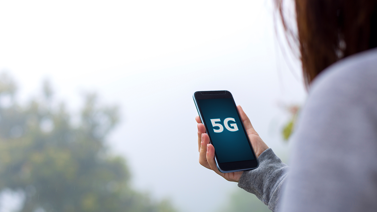 DPS, News: Trendthema 5G Frau mit Smartphone in der Hand, auf dem Bildschirm wir 5G angezeigt