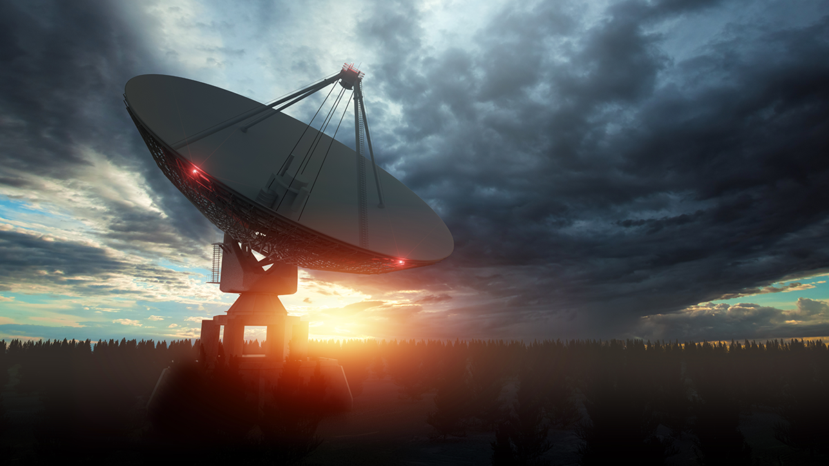 Satellietenschüssel vor einem bewölktem Himmel im Abendlicht