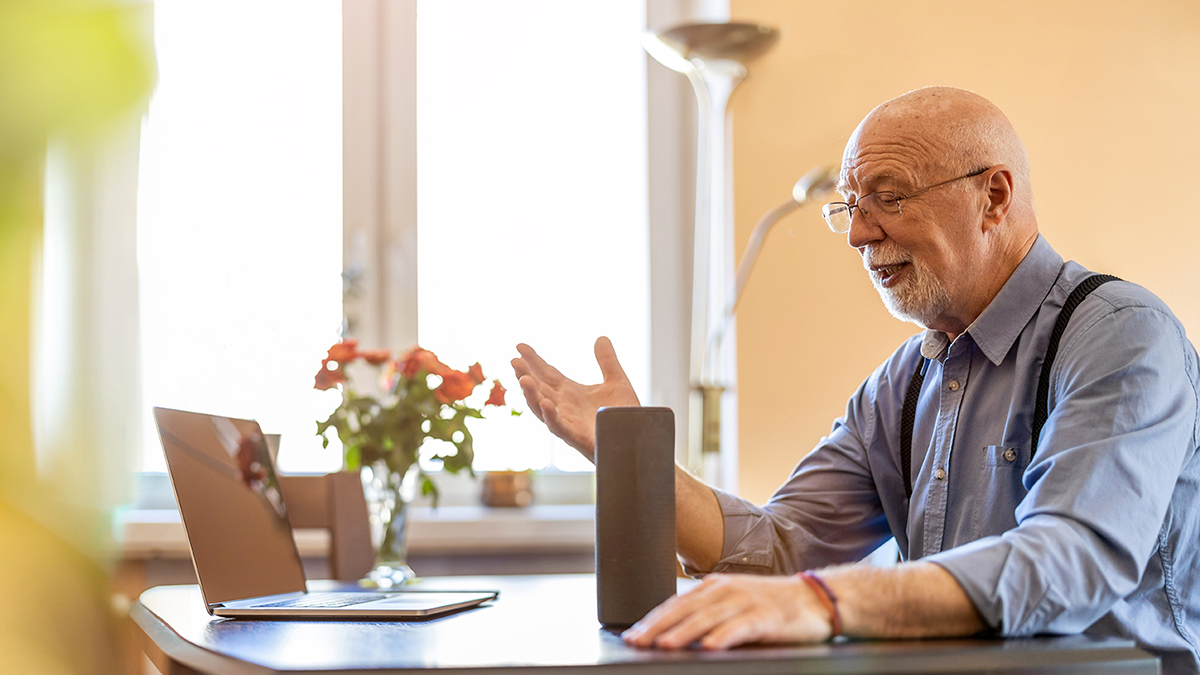 Senior man using Virtual Assistant at home