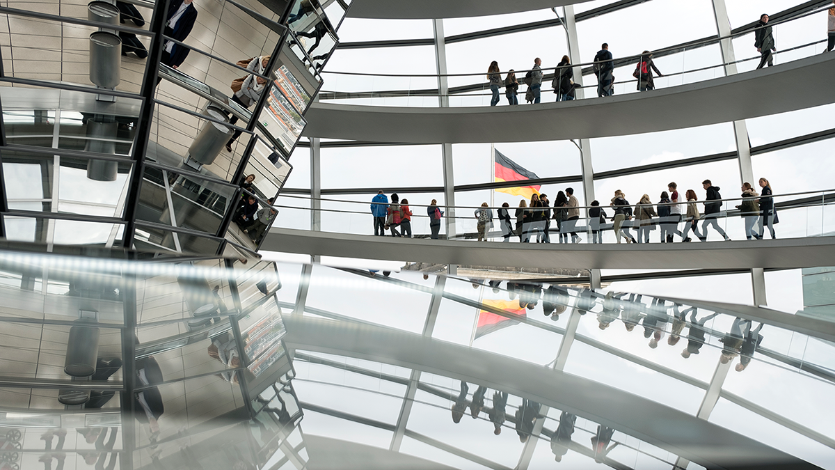 Besucherinnen und Besucher laufen in der Kuppel des Reichstagsgebäudes in Berlin