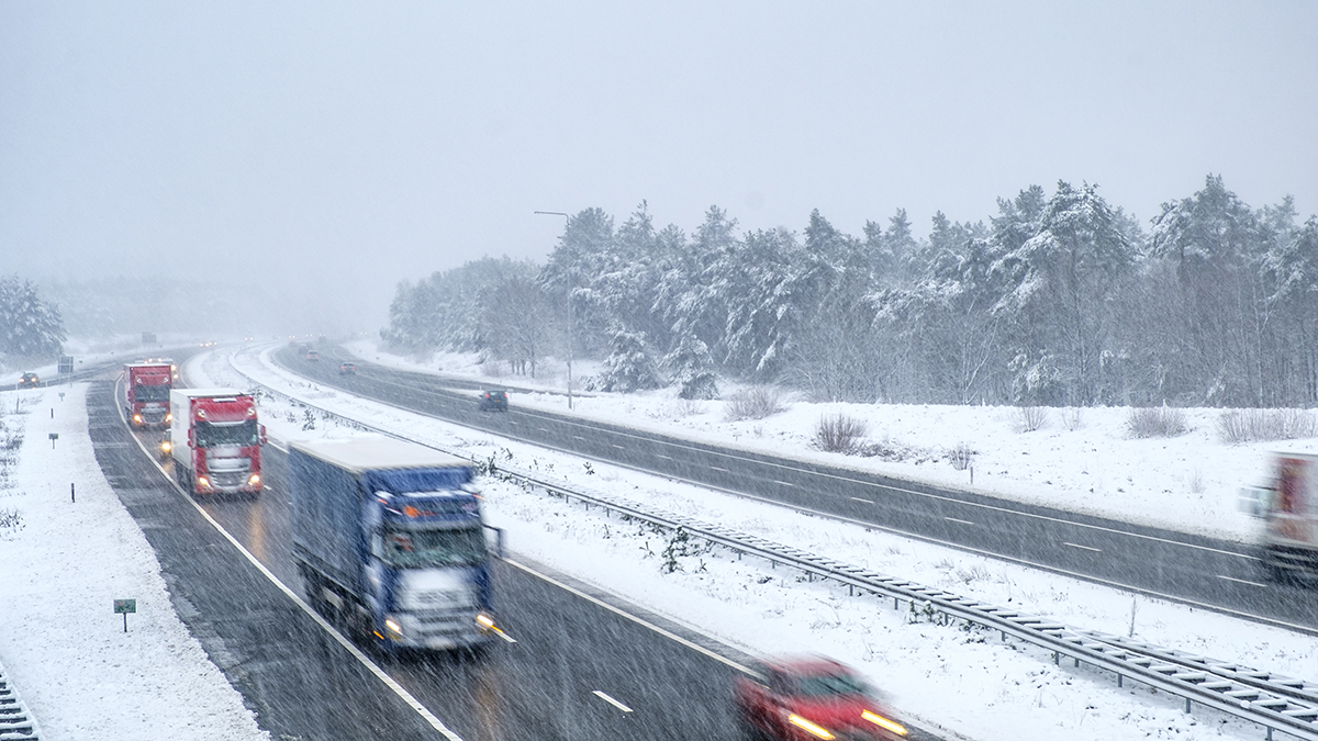 Traffic on a slippery and dangerous highway through the Veluwe forest in Gelderland, The Netherlands, during a snow blizzard in winter