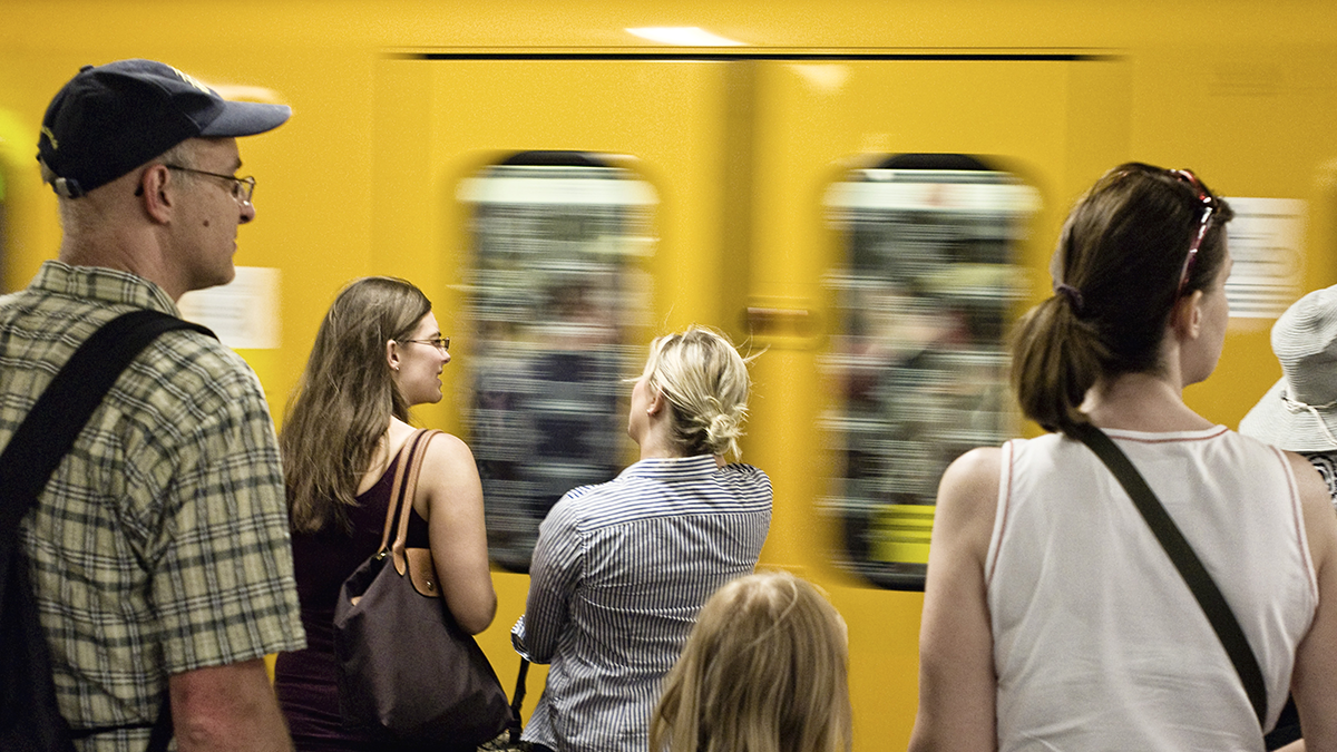 Fahrgäste während der Einfahrt einer U-Bahn in den Bahnhof am Bahnsteig