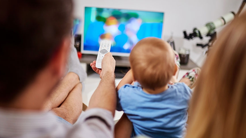 FAME, News: Over-the-top (OTT) Ad-Tech-Angebot Eine Familie mit Baby schaut Fernsehen.