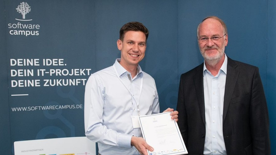 Dr. Christopher Krauss nimmt seine Abschlussurkunde für das Software Campus Mentoring Programm entgegen