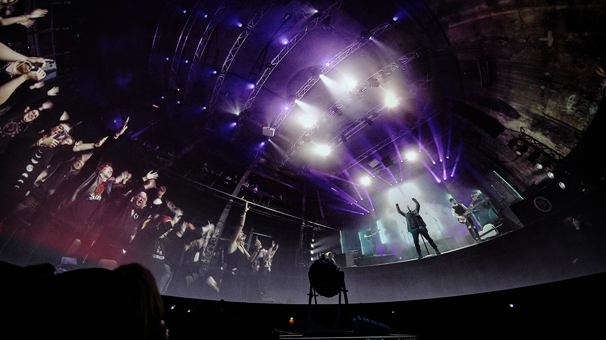 Kuppel eines Planetariums in die ein Livekonzert des Künstlers The Dark Tenor mit Publikum und Bühne in Echtzeit projiziert wird.