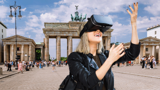 Frau mit VR-Brille vor Brandenburger Tor