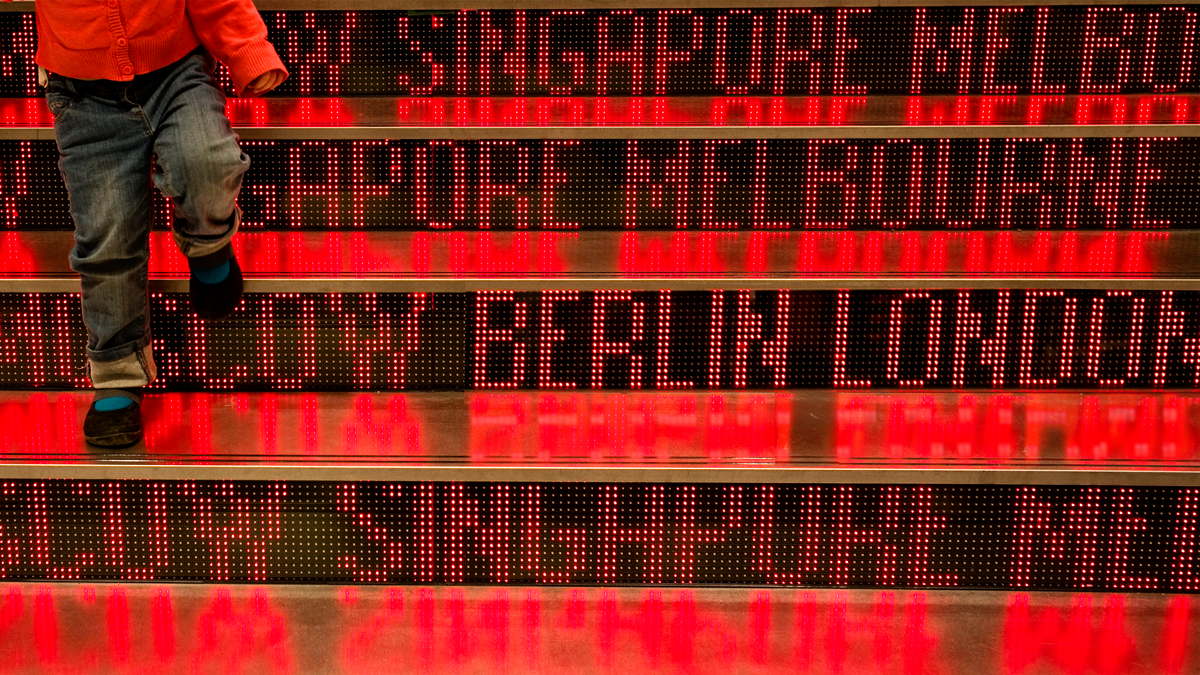 FOKUS, News: Künstlicher Intelligenz in der Praxis Eine Person steigt eine beleuchtete Treppe hinab.