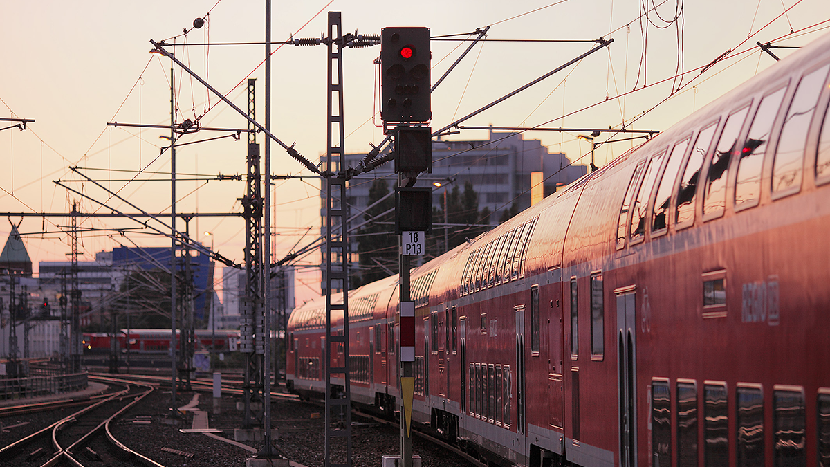 Zwei Regionalzüge der DB fahren durch Berlin Mitte durch eine Gleisanlage, Abendstimmung