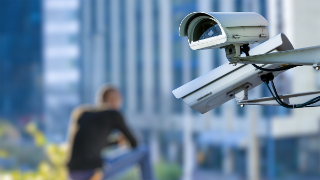 security CCTV camera or surveillance system with young man on blurry background