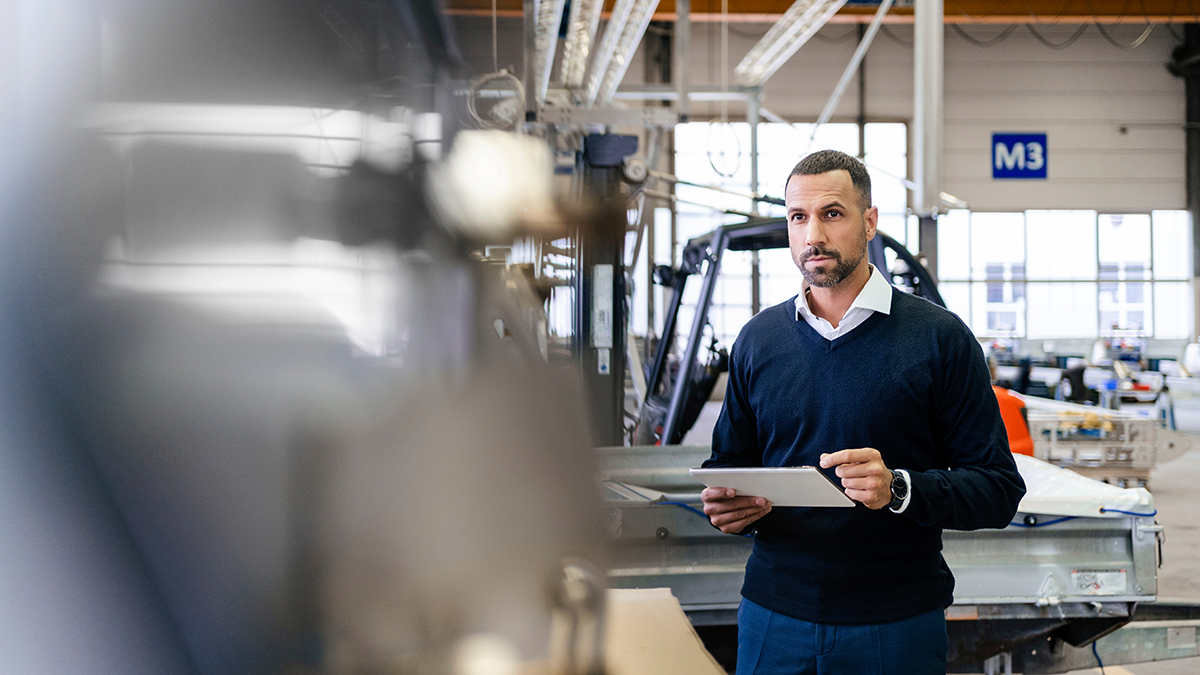 Businessman using tablet in a factory