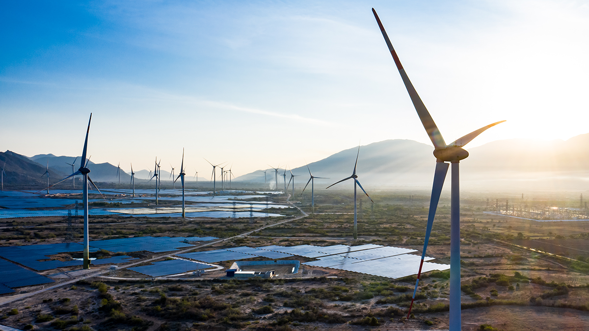 Panoramic view of wind farm or wind park, with high wind turbines for generation electricity with copy space. Green energy concept to reduce global warming and climate change.