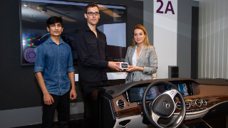 Der Studentin mit dem besten Testfahrt-Ergebnis wird ein Preis überreicht. Auch der Zweitplatzierte wird von FOKUS-Forscher Daniel Becker bei der Siegerehrung gewürdigt.