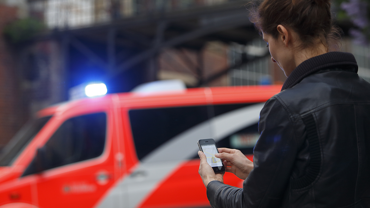 ESPRI, Projekt, Vorschaubild: ENSURE NEF (Noteinsatzfahrzeug) der Feuerwehr auf dem Gelände des Westend-Klinkums in Berlin; Frau mit Handy im Vordergrund, Mai 2013