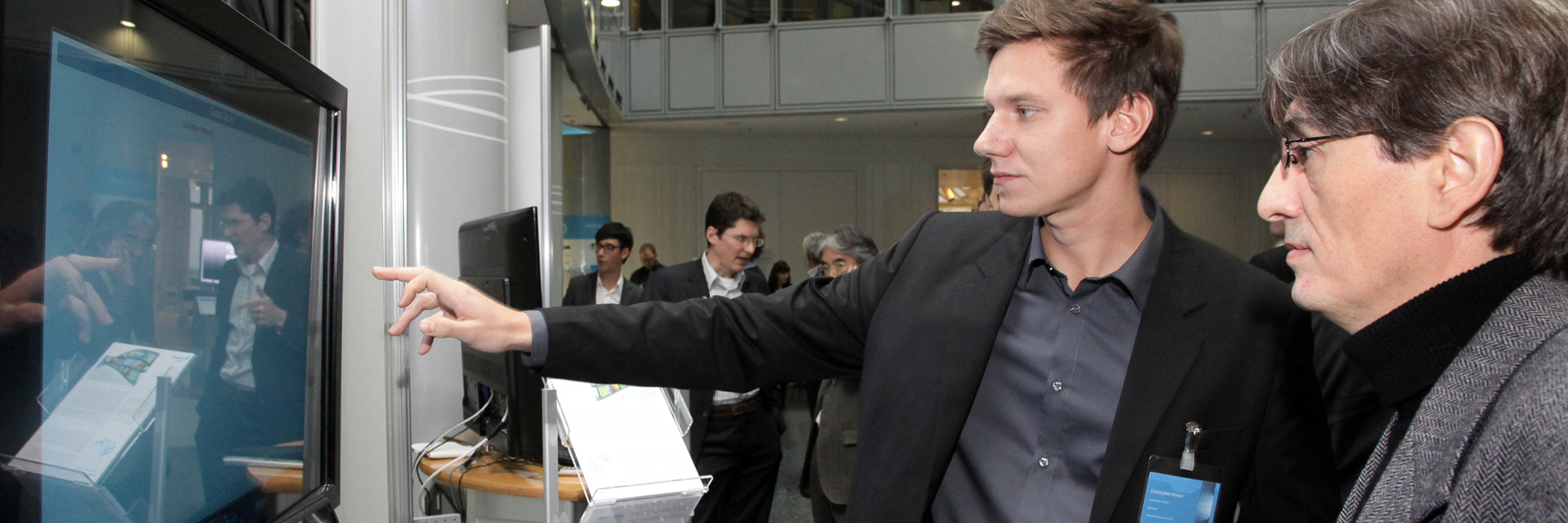 Headerbild des MWS 2011: Christopher Krauß im Gespräch mit einem Konferenzteilnehmer bei einem Demostand