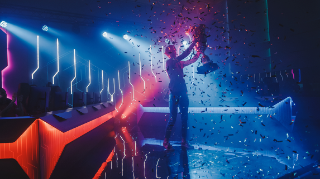 FAME, News: Video Development Blog Eine Person hält einen Pokal in die Höhe.