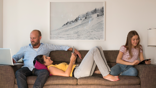 FAME, Solutions: HbbTV 2.0 Companion Screen Framework Family with different devices sits on a grey sofa smiling