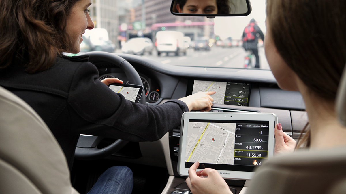 FAME, News: webinos Zwei Personen sitzen in einem Auto und benutzen jeweils ein Navigationssystem auf verschiedenen Bildschirmen.