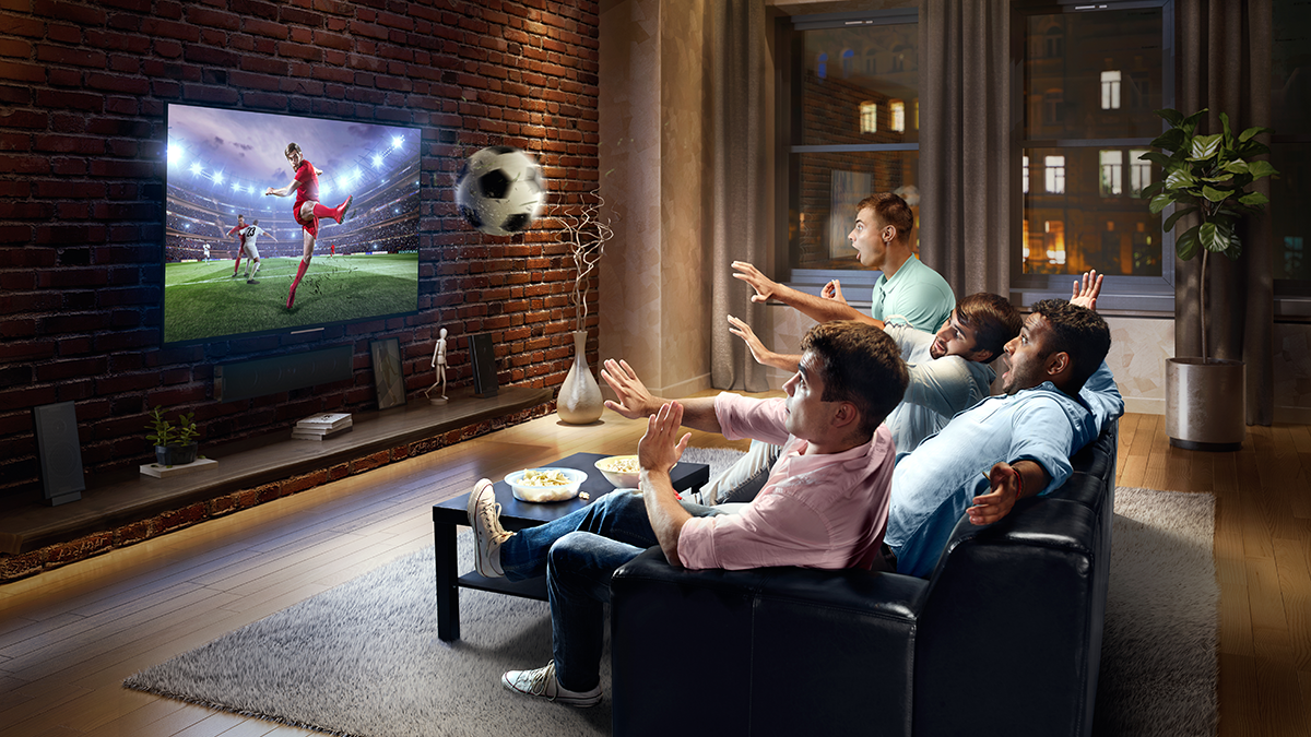 FAME, Projekte: ICE-CREAM :biggrin:A group of young male friends are shocked while watching Soccer game on TV. They are sitting on a sofa in the modern living room. The TV set is on the loft brick wall. It is evening outside the window.