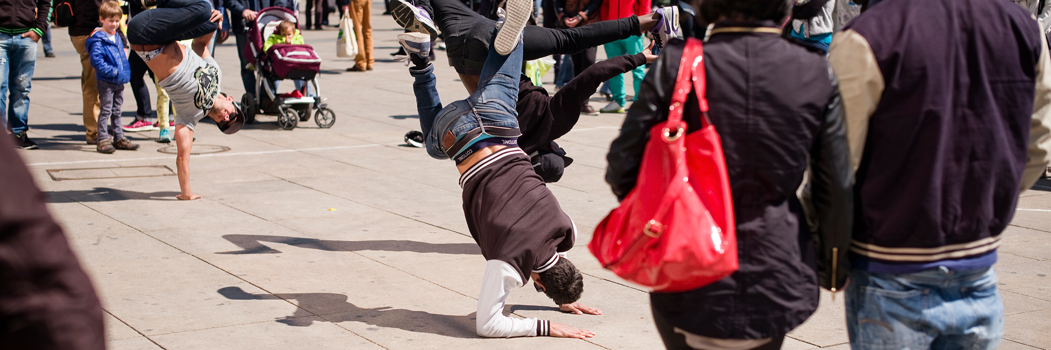 Eine Menschengruppe auf dem Berliner Alexanderplatz steht um eine Gruppe Breakdancer und beobachtet die Performance
