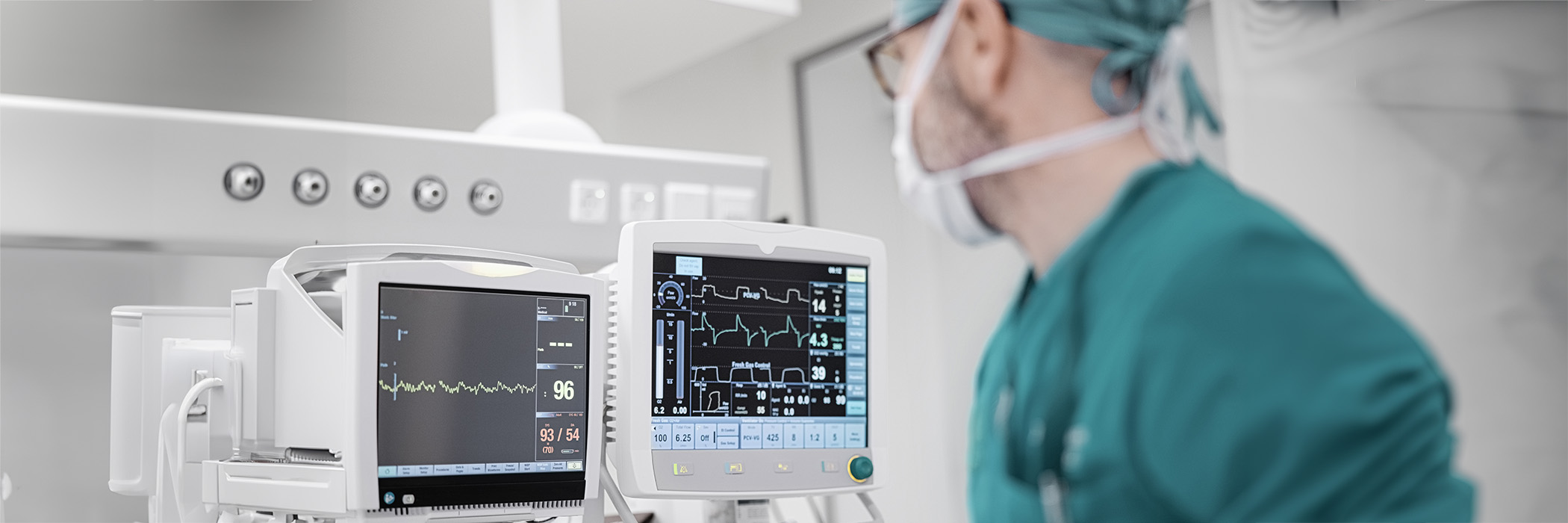 Male surgeon looking at the monitoring equipment during surgery.