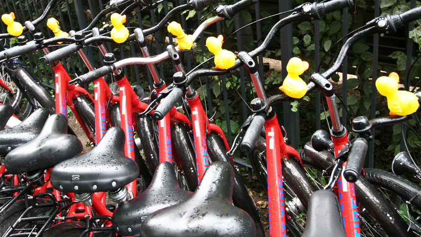 SQC, News: Global CycleHack Event 2017 Eine Reihe von roten Fahrrädern mit gelben Entenfiguren am Lenker