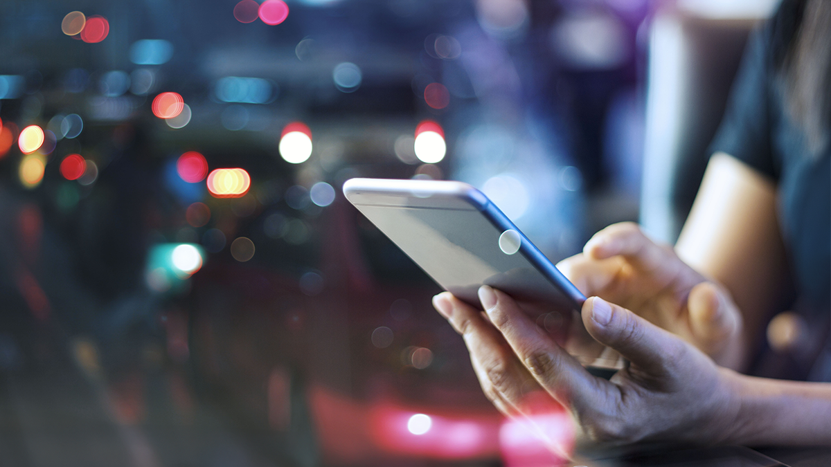 Woman using mobile smart phone in the night light colorful background